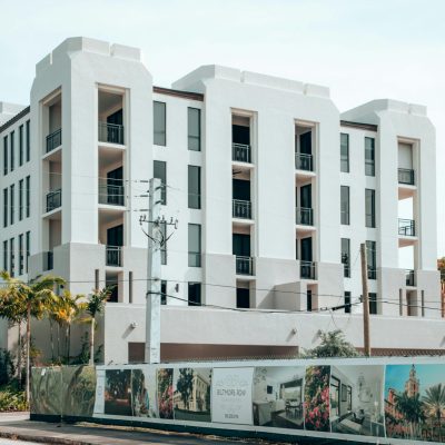 Elegant modern apartment building exterior in Coral Gables, Florida, under a clear blue sky.